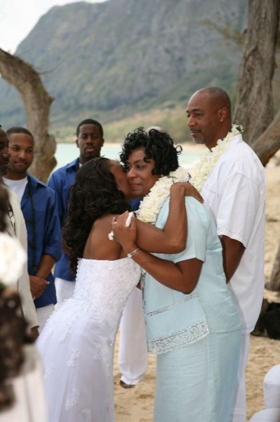 Guests seated on the sand under the ironwood trees, laughing together