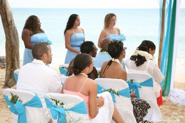 Guests seated on the sand under the ironwood trees, wide view