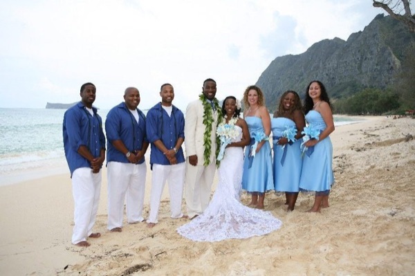 The bridal party in blue on the beach, side by side
