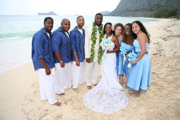 The bridal party in blue on the beach, under a blue sky