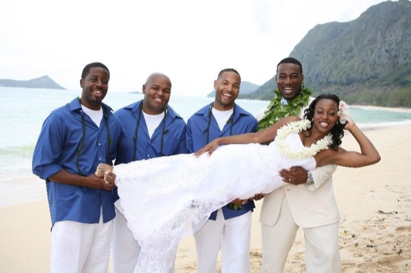 The bridal party in blue on the beach, laughing together