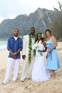 The bridal party in blue on the beach, smiling