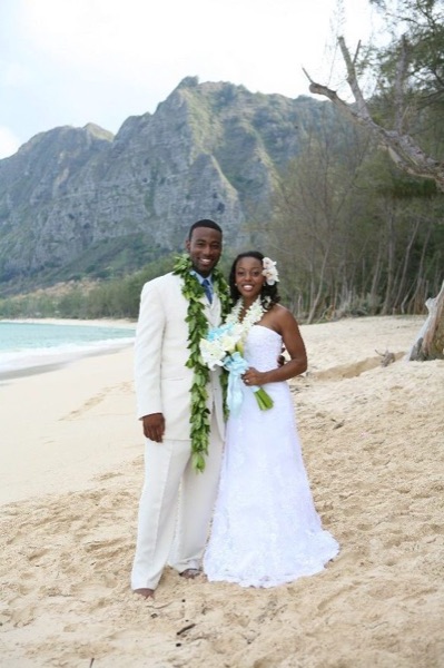 Naheshae and Damarus on the beach with the mountains behind them, smiling