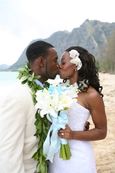 Naheshae and Damarus on the beach with the mountains behind them, in the sunshine