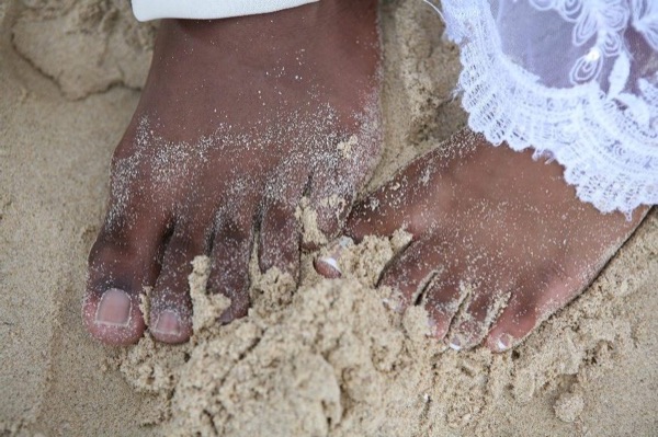 Naheshae and Damarus on the beach with the mountains behind them, arm in arm
