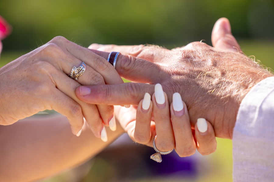 Close-up of the couple's hands as they exchange wedding rings