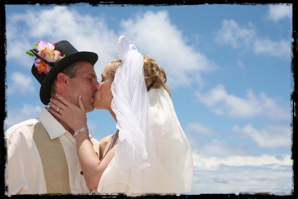 Groom in a top hat with Mickey Mouse ears and the bride in a Mickey Mouse veil