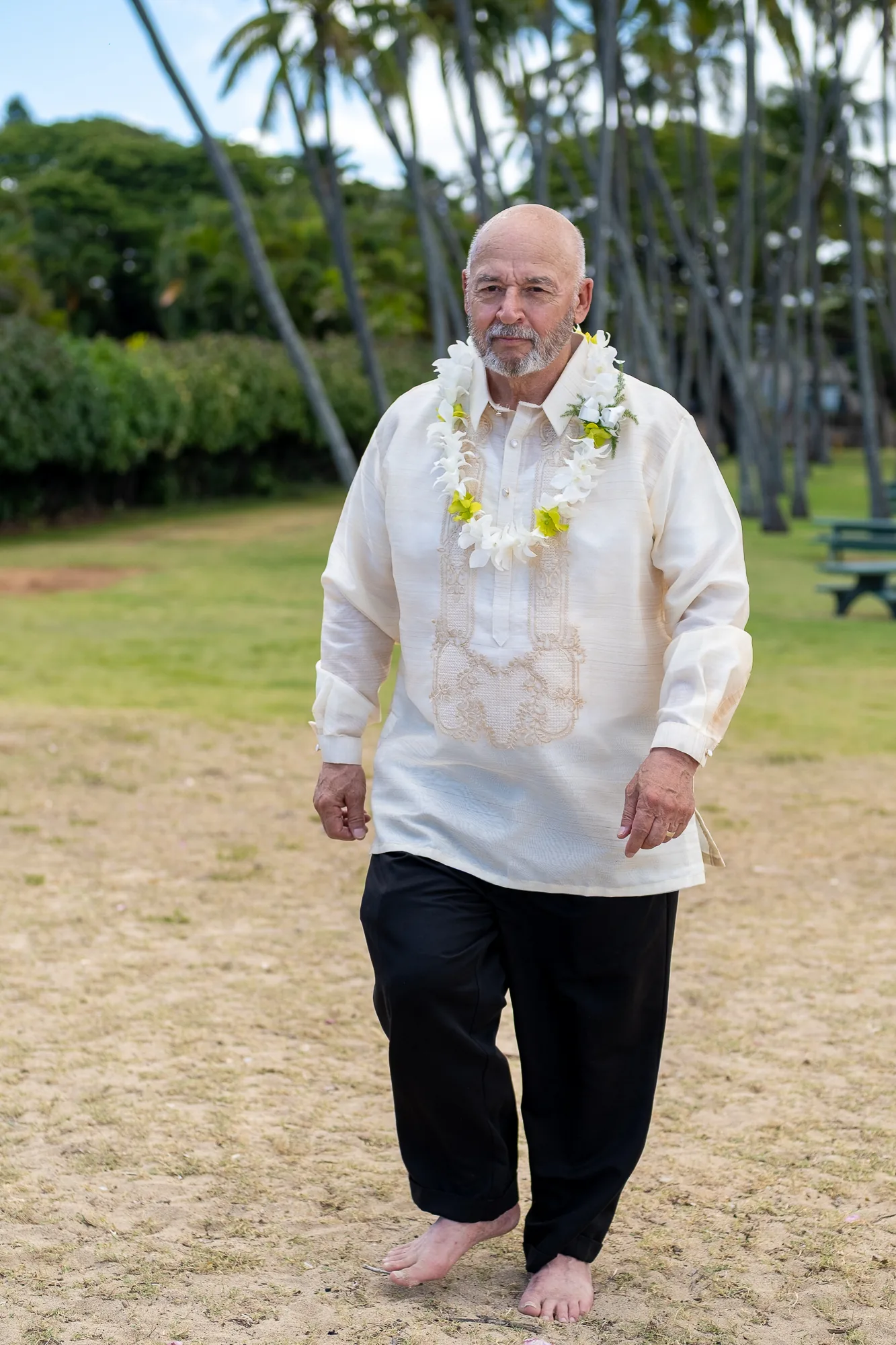 A father in white walking down the aisle