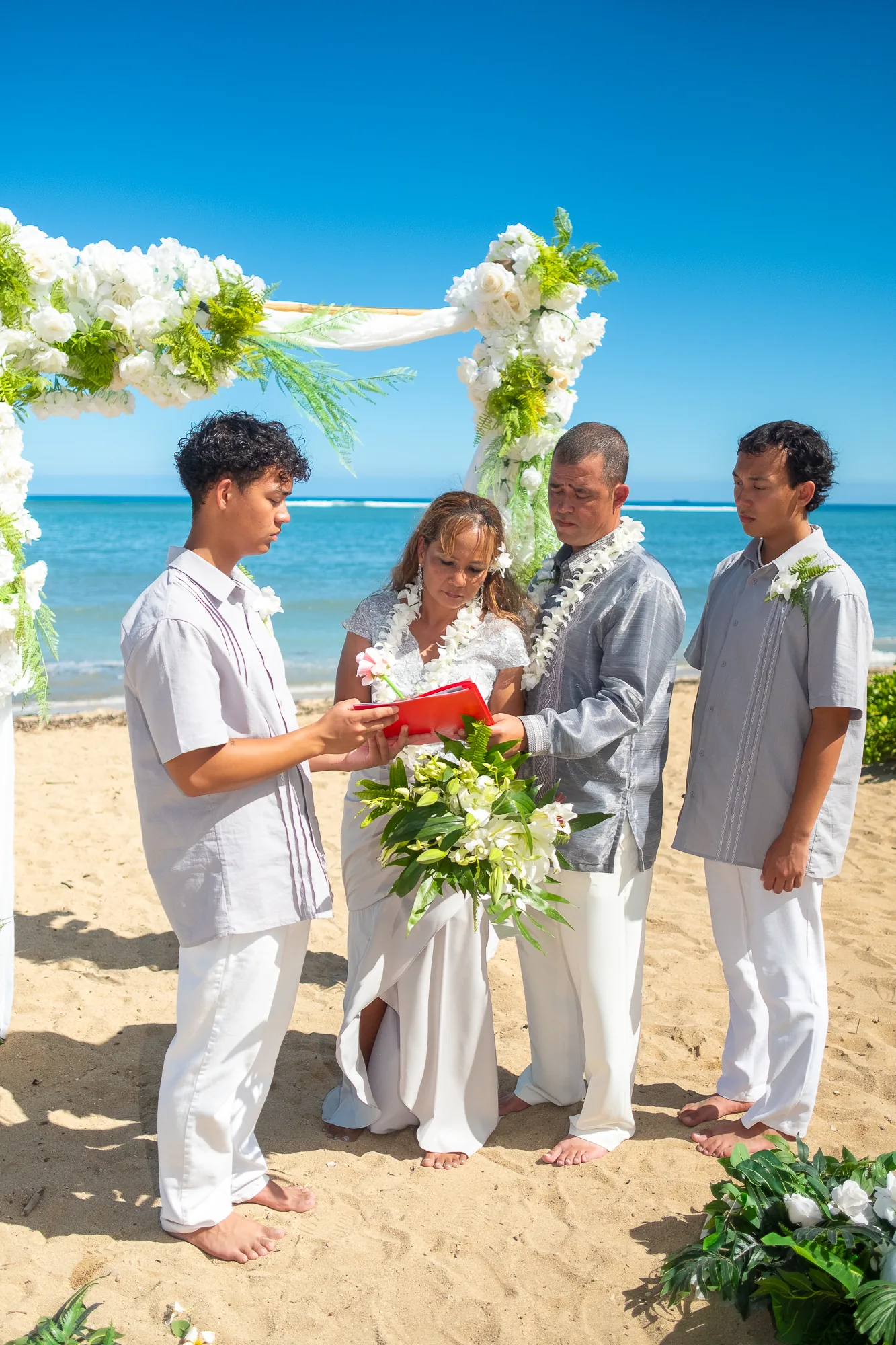 Rose, Nate and their sons at the white and green flower arch