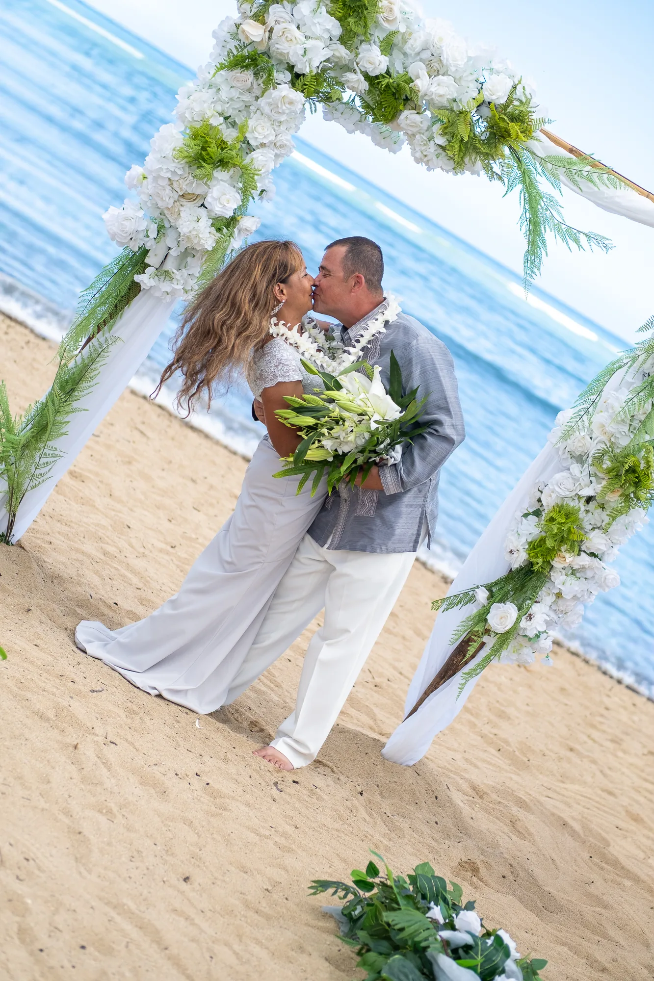 A kiss at the arch with the sea behind