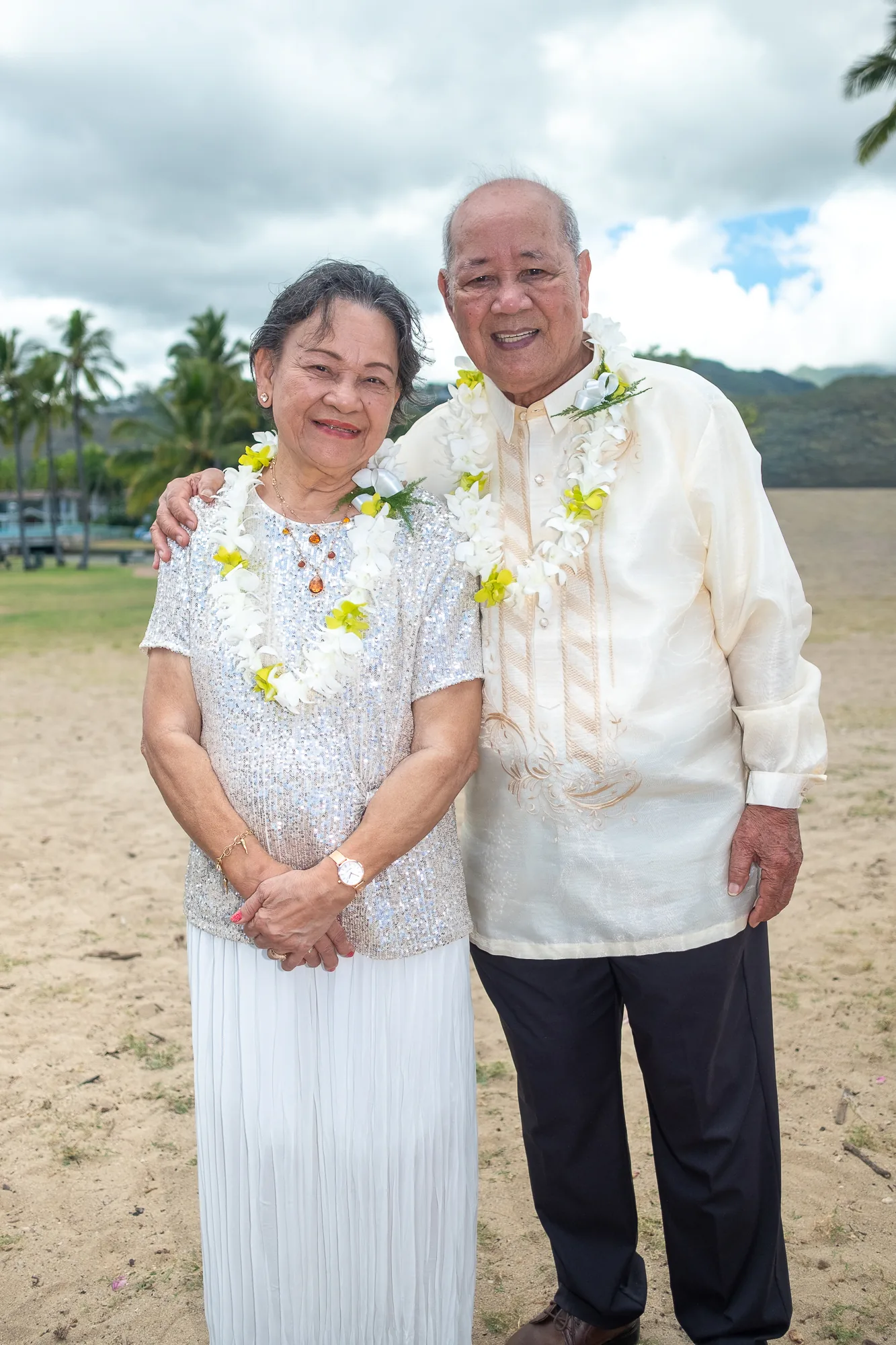 Their parents in white with flower leis