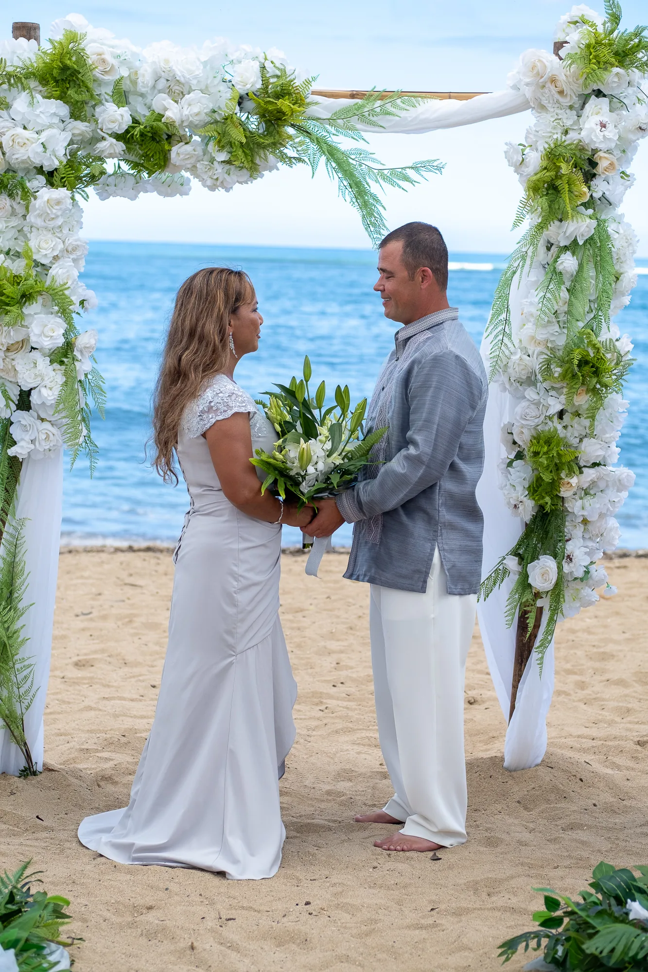 Rose meets Nate at the bamboo arch draped in white chiffon