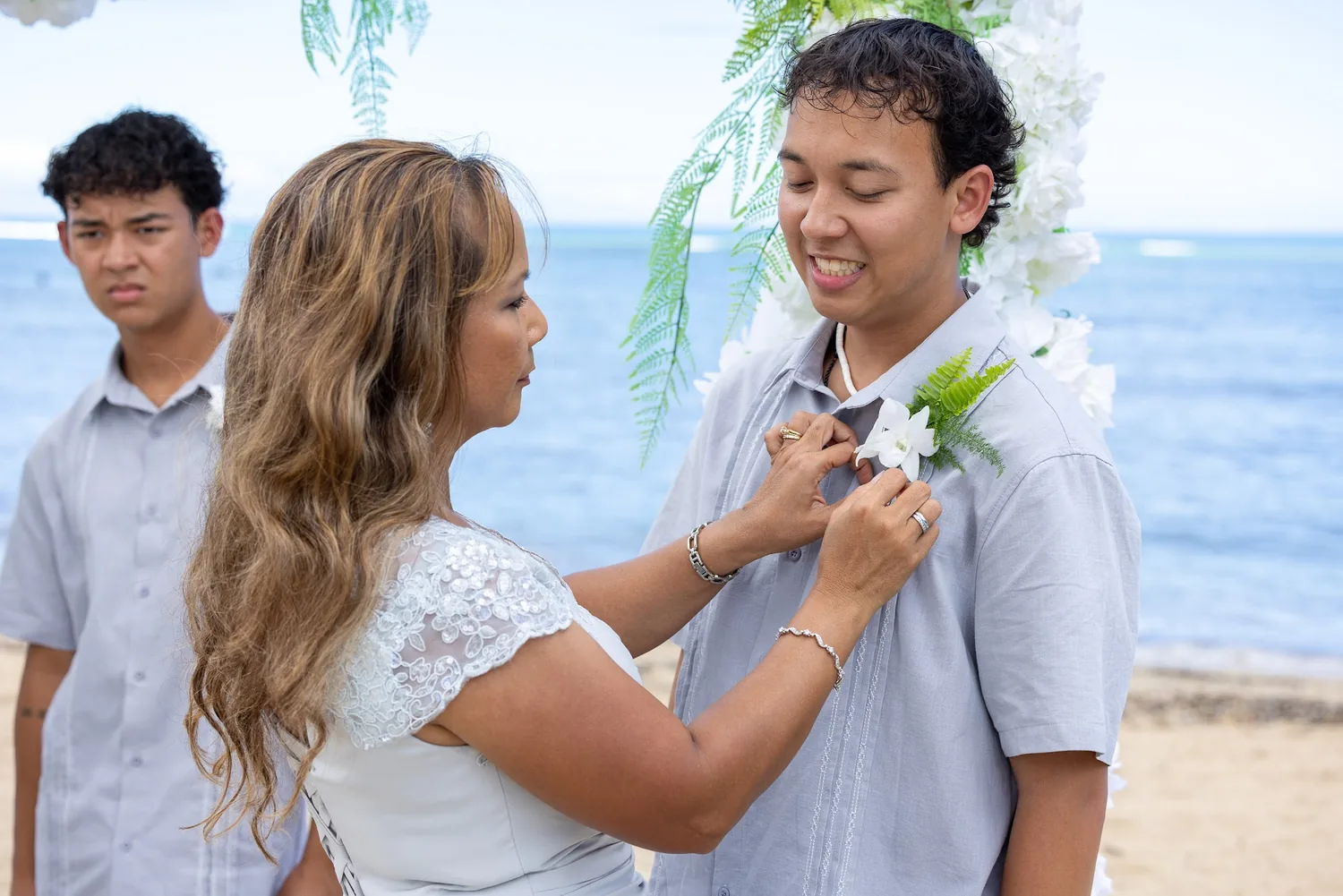 Rose pinning a boutonniere as her other son looks on