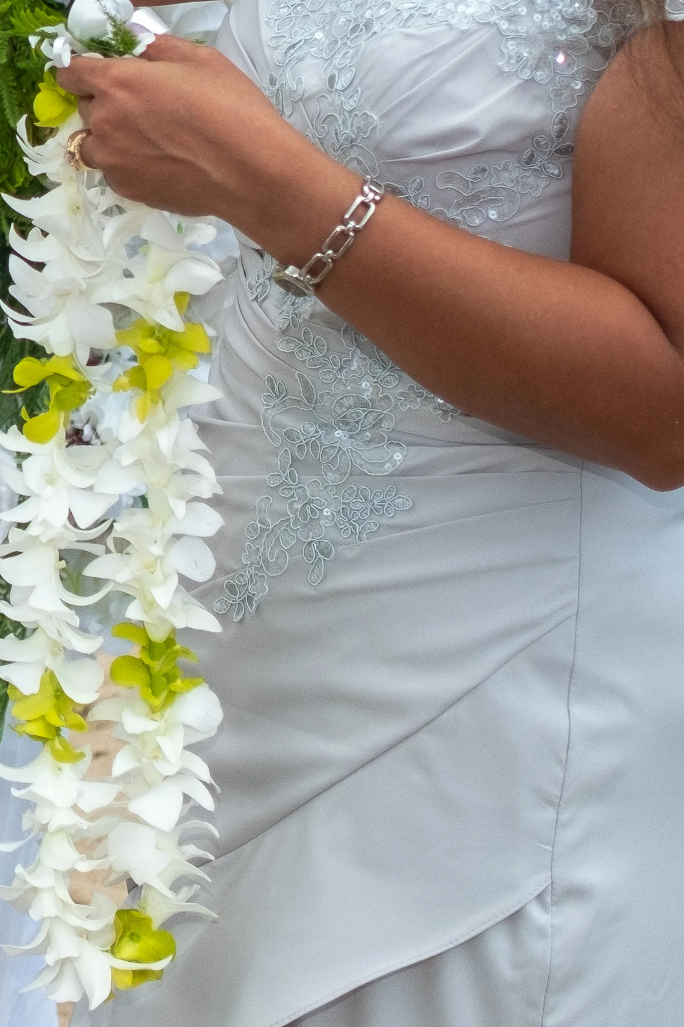 Her white orchid lei and bracelet