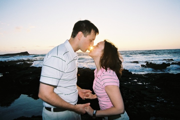 Karen and James sharing a kiss by the ocean at sunrise at Makapuu