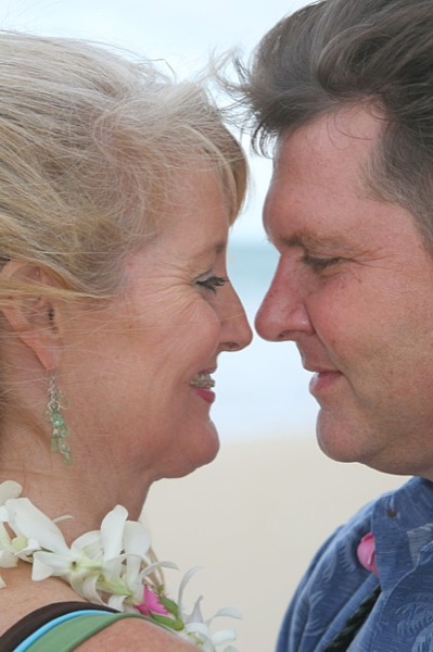 Friends and family with Teri and Dennis on the beach, looking at each other