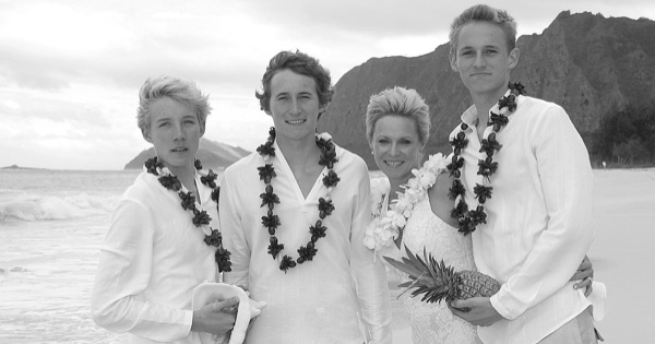 The kids in their leis on the sand, close together