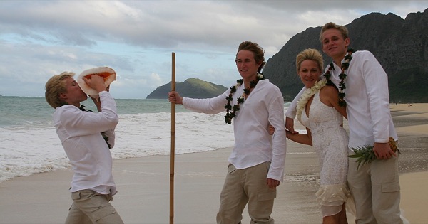 The kids in their leis on the sand, looking at each other