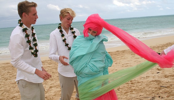 The kids in their leis on the sand, in a happy moment