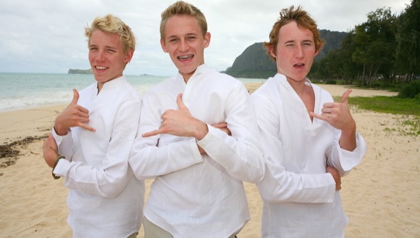 The kids in their leis on the sand, up close