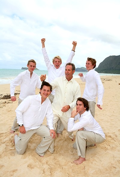 The kids in their leis on the sand, side by side