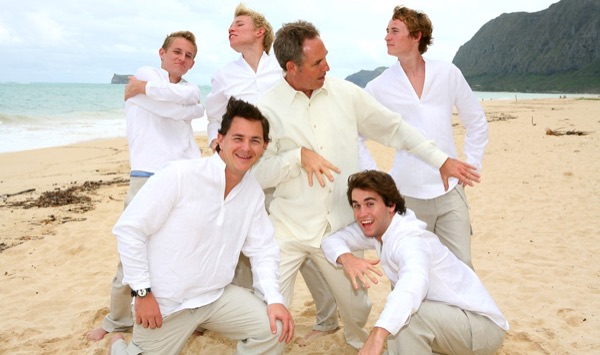 Teri and Dennis with their children on the beach, side by side