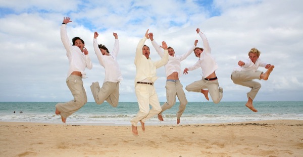 The kids in their leis on the sand, laughing together