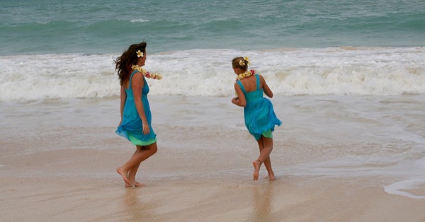 Teri and Dennis with their children on the beach, laughing together