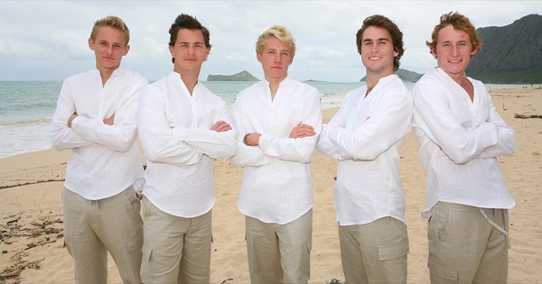 The kids in their leis on the sand, smiling