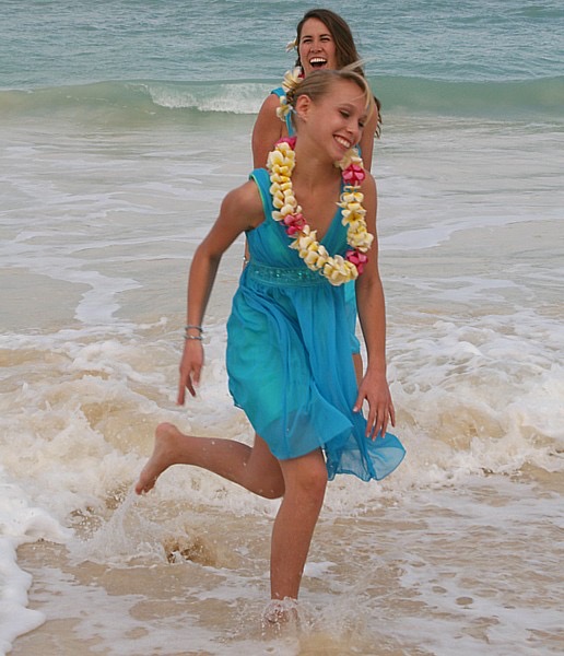The kids in their leis on the sand