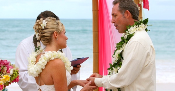 Guests watching the vow renewal on the sand, from another angle