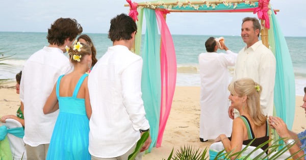 Guests watching the vow renewal on the sand