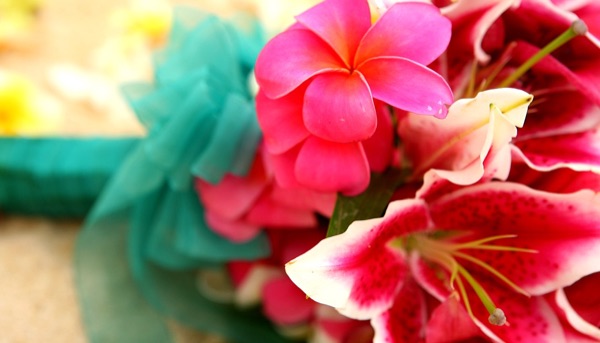 Bright pink plumeria on a bouquet for a wedding on the beach