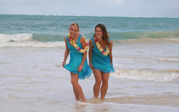 The kids in their leis on the sand, close up