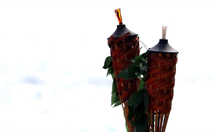 Bamboo tiki torches decorated with flowers at a ceremony at Paradise Park