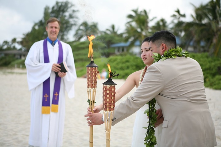 Rev. Chris Cain looking on as the couple lights the fire torch