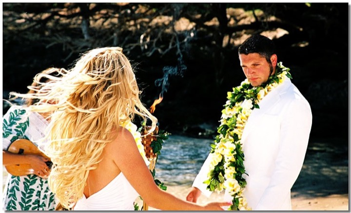Newlyweds serenaded by a ukulele singer while the tiki torches burn