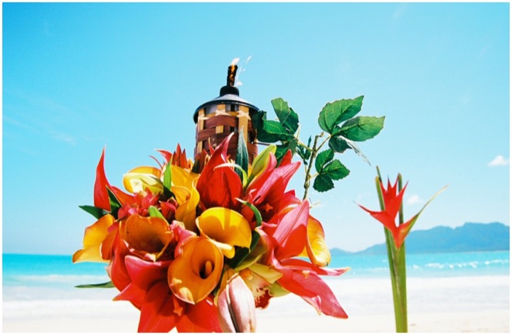 Tiki torch decorated with bright tropical Hawaiian flowers