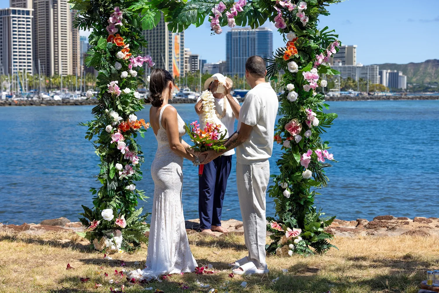 Wide view of the ceremony at the arch by the water