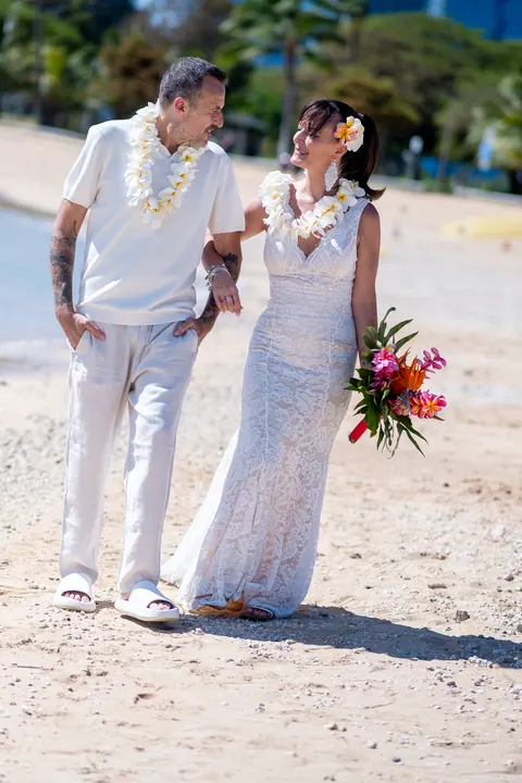 Her bouquet and white dress on the sand