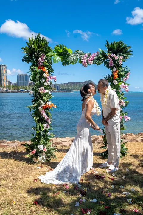 Holding hands at the arch with the ocean behind