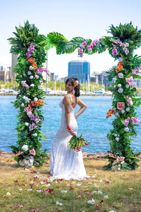 Sara at the flower arch with the city across the water