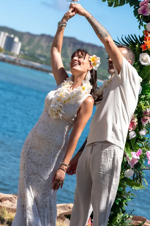Sara holding her vow card in a white lei