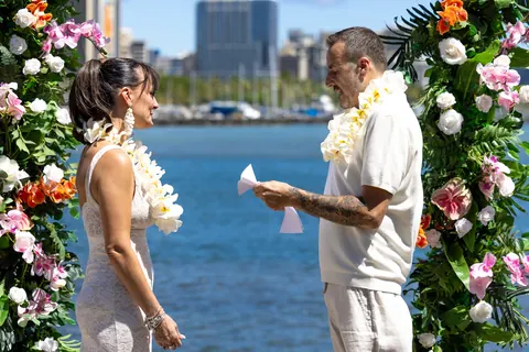 Vows at the arch with the city skyline behind