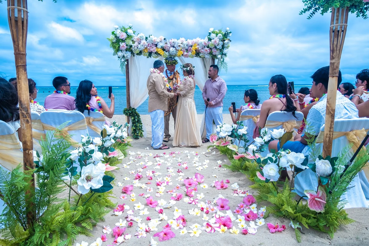 Wide view of the ceremony with the family in lavender and the ocean behind