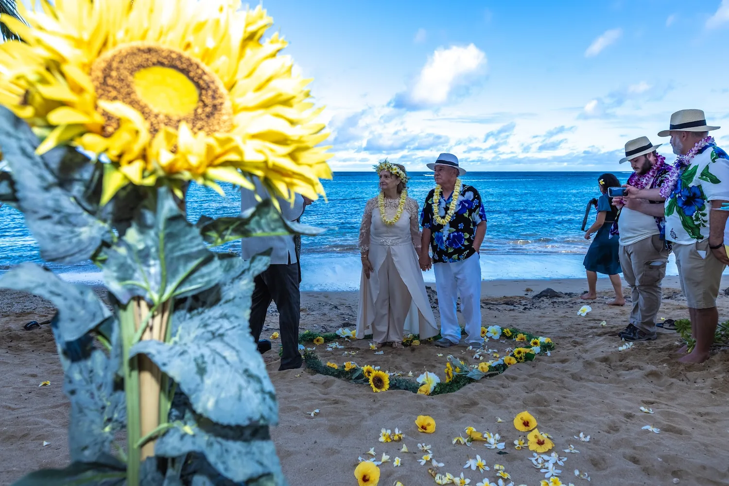 A big sunflower arrangement with the couple and guests behind