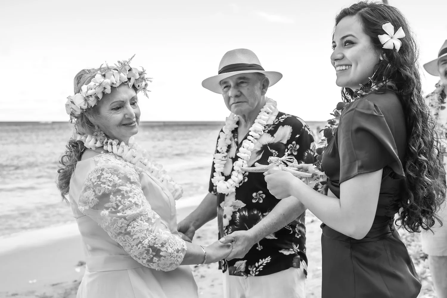 Black and white photo of the couple with family by the sea