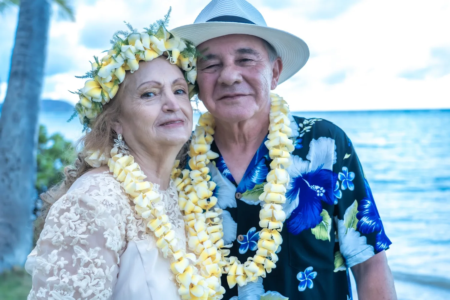 Daniel and Shirley smiling cheek to cheek in leis