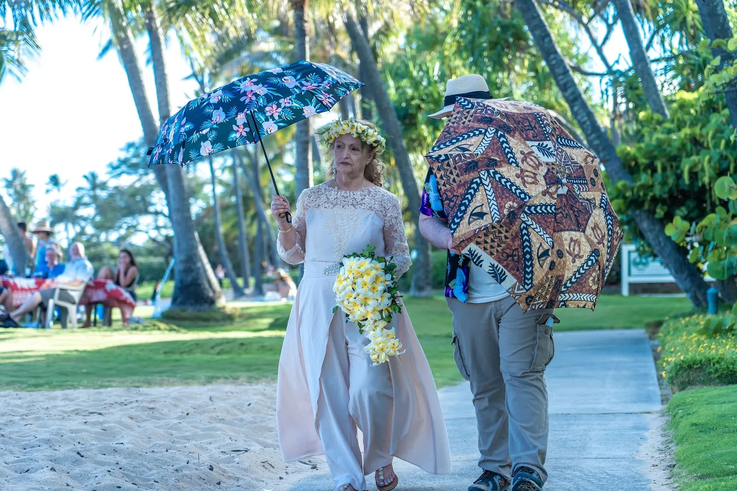 Daniel and Shirley walking to the beach under colorful umbrellas