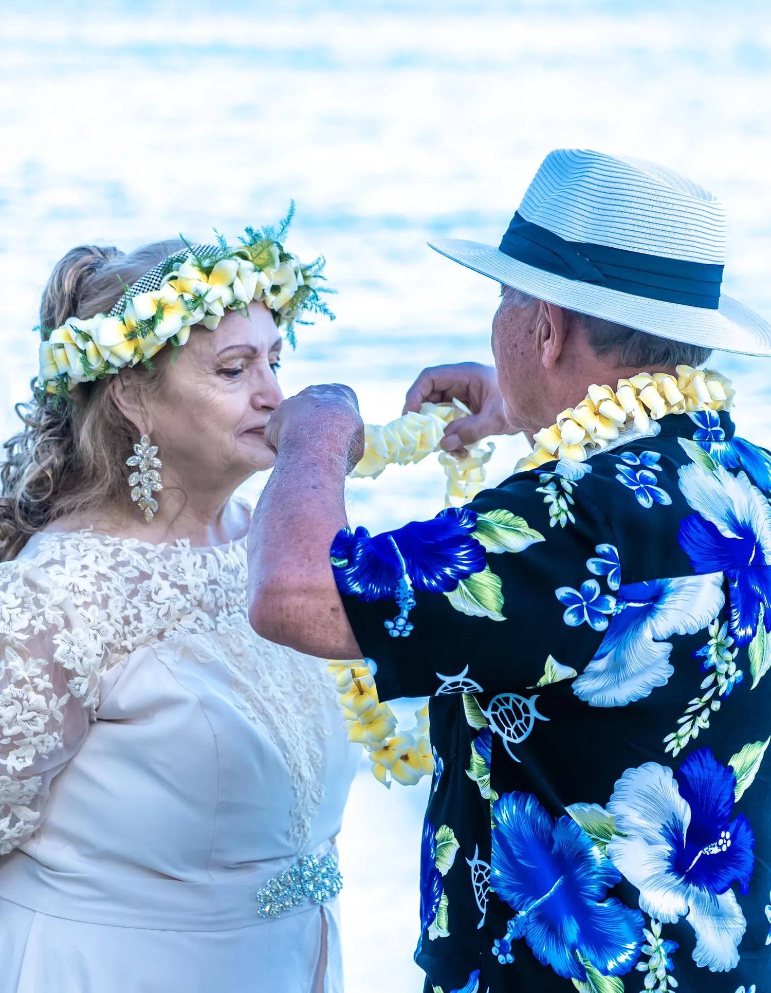 Daniel placing a yellow plumeria lei on Shirley